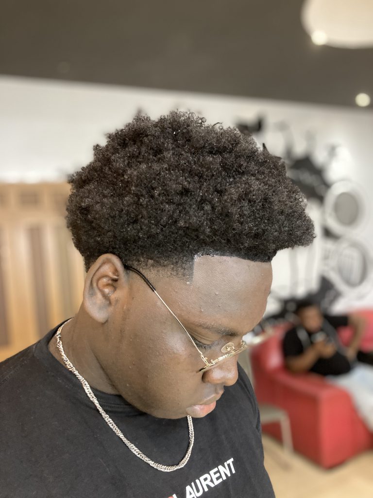 jeune au salon pour faire pousser cheveux afro